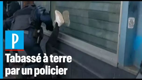 Un manifestant frappé à terre par un policier