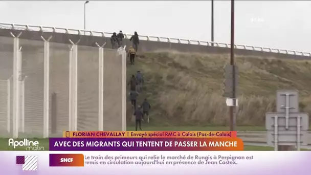 Un groupe de migrants ouvrent et sautent dans un poids lourd en mouvement.