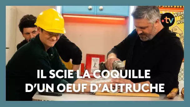 Il scie la coquille d'un oeuf d'autruche géant en direct sur le plateau