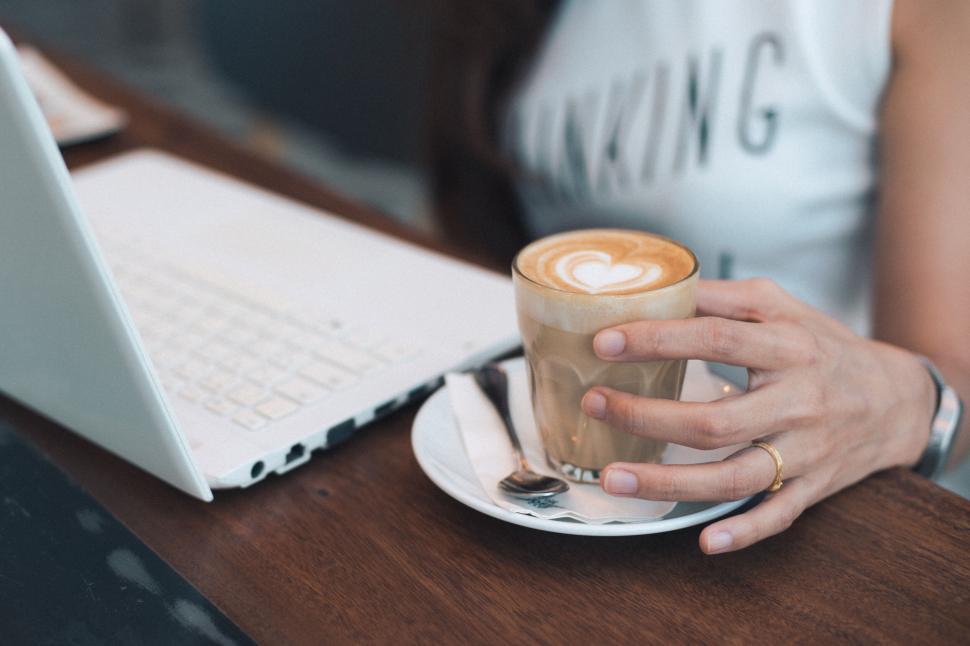 woman-holding-a-cappuccino-at-a-cafe